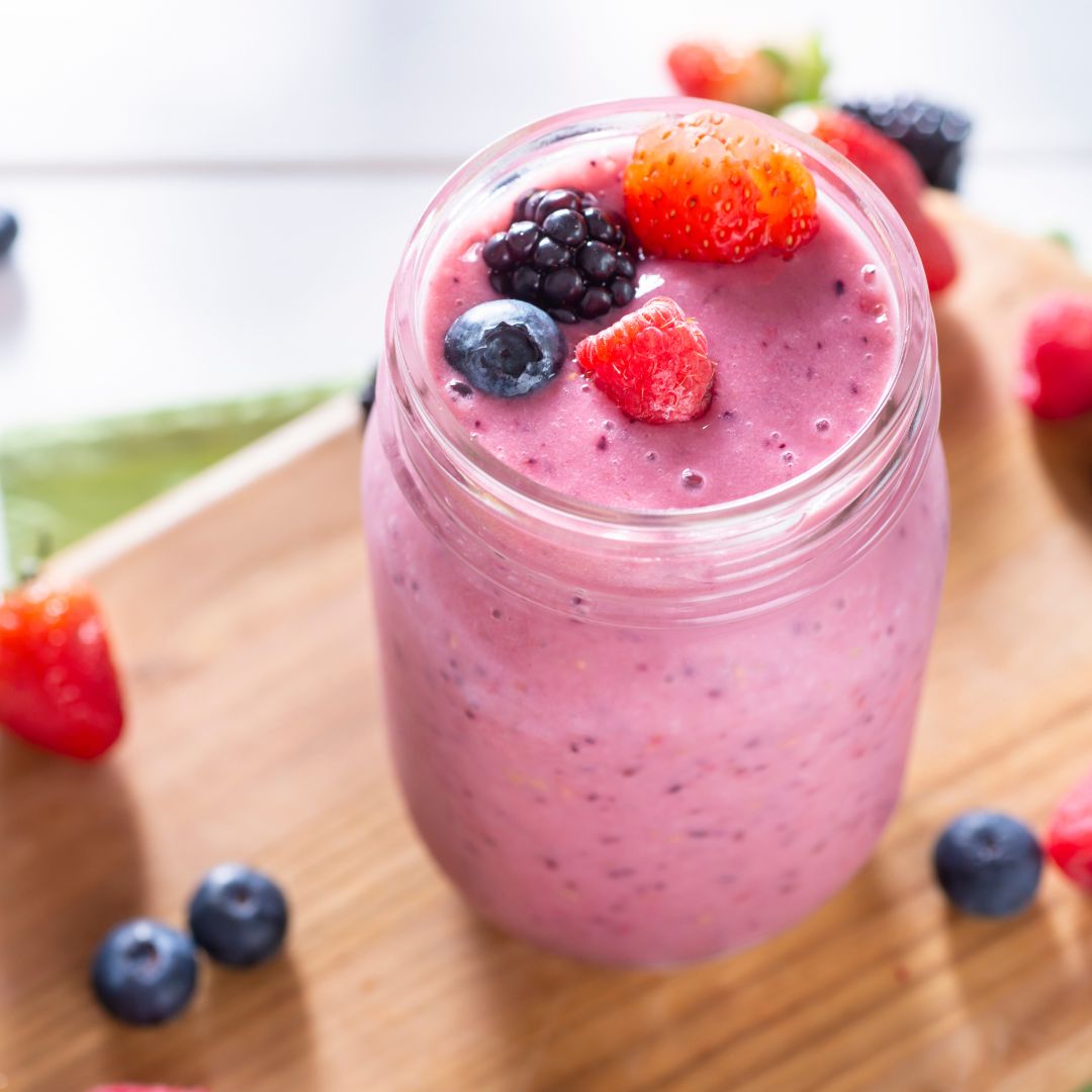 Summer berry smoothie topped with chopped nuts and seeds as a colourful, protein-rich breakfast